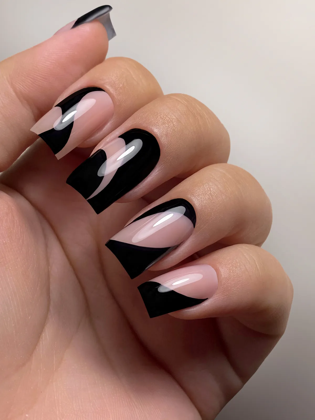 Nude nails with graphic black tips that leave part of the nail bare